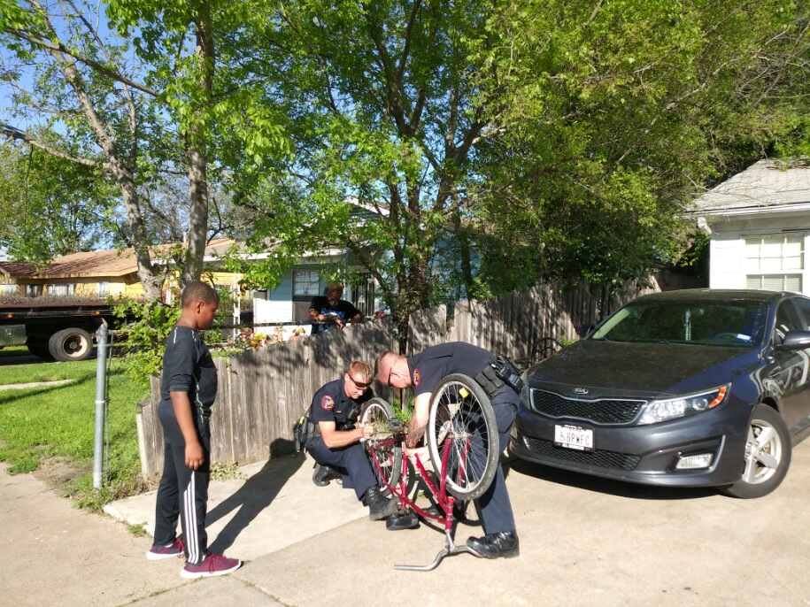Officers Asmus and Leach help boy with bike chain