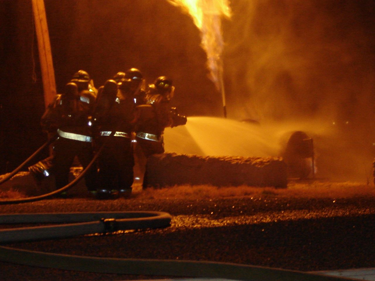 Firefighters putting out fire with water hose (JPG)